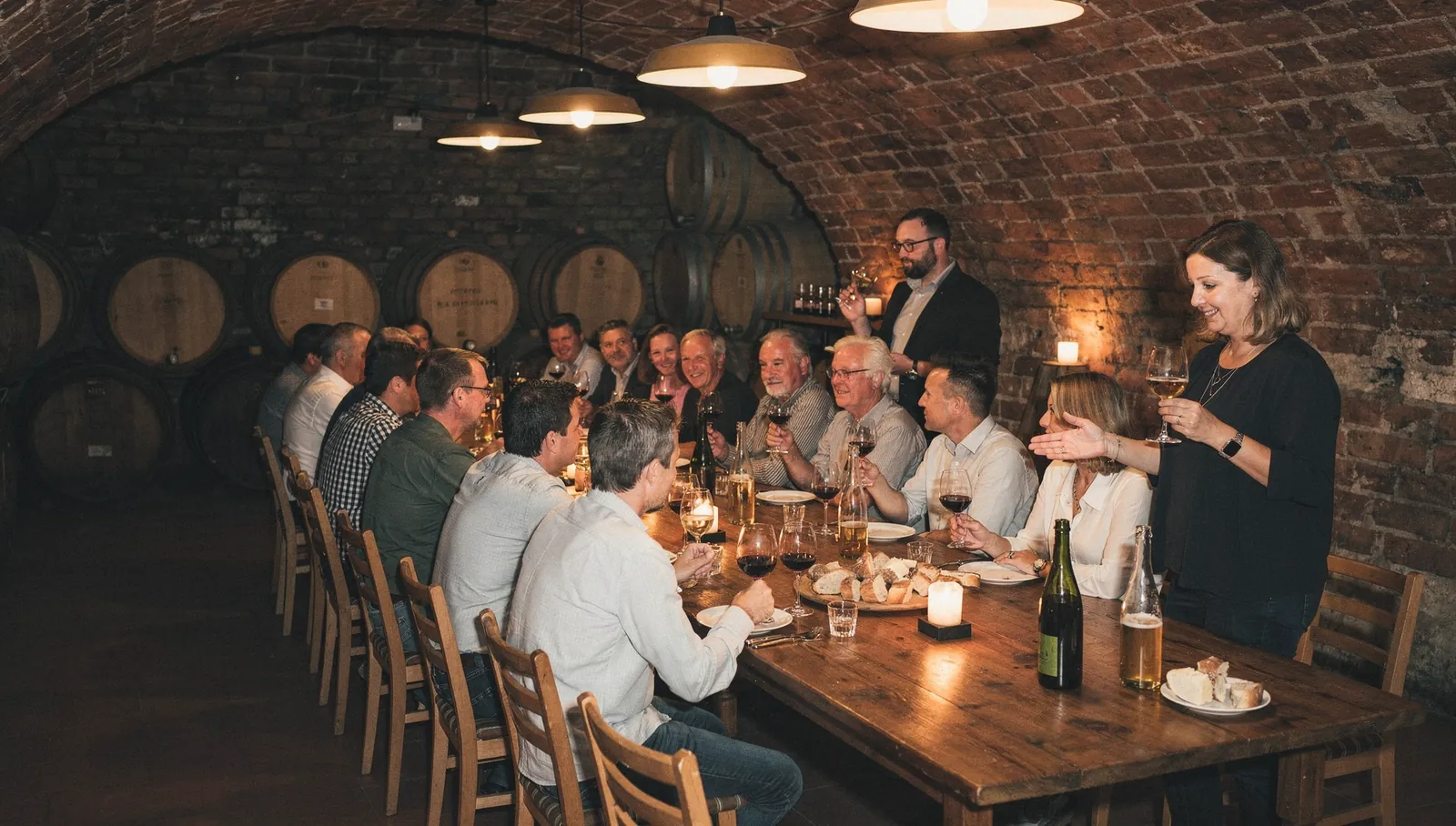 A group of guests at a wine tasting in the vaulted cellar of a winery